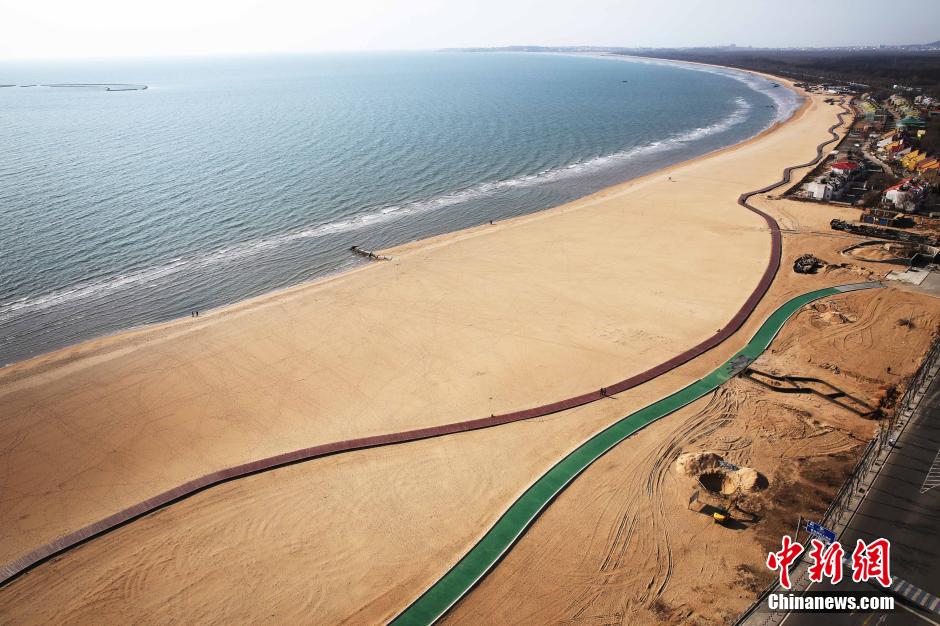 3月13日，秦皇島萬(wàn)米臨海沙灘木棧道。據了解，該木棧道全長(cháng)約4200米，與北戴河區原有的7500米木棧道對接后全線(xiàn)總長(cháng)度1.17萬(wàn)米，整個(gè)木棧道東起秦皇島體育基地游船碼頭，西至北戴河濕地公園，呈波浪形蜿蜒10.4公里海岸線(xiàn)。 中新社發(fā) 曹建雄 攝 CNSPHOTO