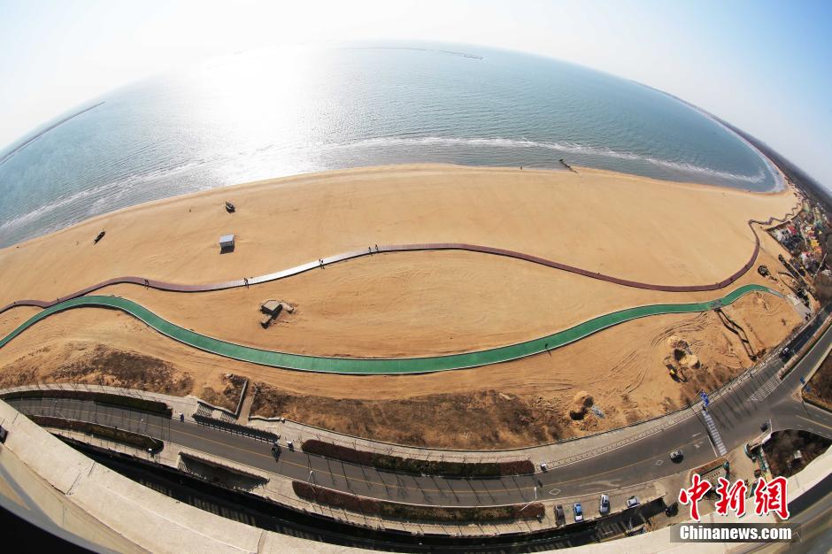 3月13日，秦皇島萬(wàn)米臨海沙灘木棧道。據了解，該木棧道全長(cháng)約4200米，與北戴河區原有的7500米木棧道對接后全線(xiàn)總長(cháng)度1.17萬(wàn)米，整個(gè)木棧道東起秦皇島體育基地游船碼頭，西至北戴河濕地公園，呈波浪形蜿蜒10.4公里海岸線(xiàn)。 中新社發(fā) 曹建雄 攝 CNSPHOTO
